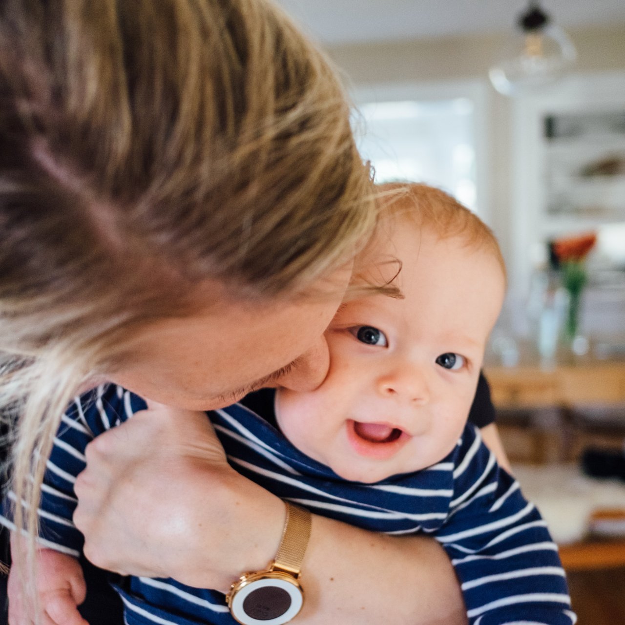 Mutter küsst ihr Baby auf die Wange. 